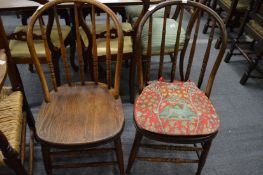 A pair of ash and elm spindle back dining chairs.
