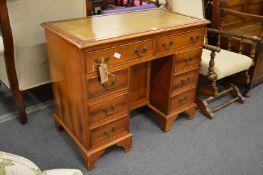 A small yew wood pedestal desk.