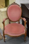 A Victorian walnut open armchair.