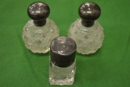 A pair of small cut glass silver mounted scent bottles and another similar.