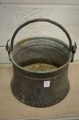 A copper vessel with wrought iron handle.
