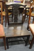 A carved oak solid seat dining chair.