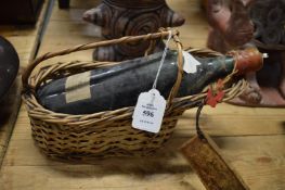 An old bottle of wine with a wicker wine pourer.