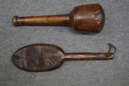 A carved wood paddle and a stone masons mallet.