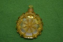 A cut glass amber coloured circular scent bottle and stopper.