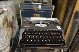 Two old typewriters and a box containing gramophone records.