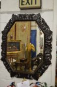 A large octagonal shaped wall mirror with carved and pierced dark oak frame.