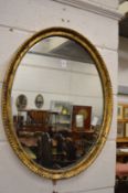 An oval gilt framed wall mirror.