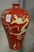 A Chinese red glazed Meiping vase with dragon decoration.
