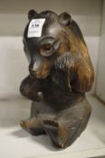 A black forest style carved wood seated bear.