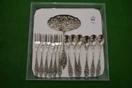 A set of six Continental silver spoons with matching forks and a serving spoon.