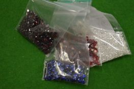 Various bags of coloured spinels.