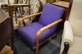 An Art Deco style armchair with curving arms.