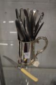 A plated tankard and a small group of knives.