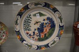 An early polychrome decorated tin glazed circular dish (faults).