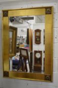 A large modern gilt framed wall mirror.