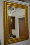 A large decorative gilt framed wall mirror.