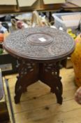 A small Eastern carved wood table.