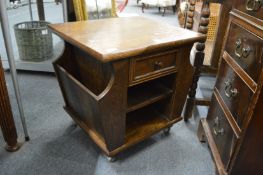 An oak single drawer occasional table with magazine storage and open shelves.