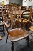 A 19th century yew and elm wheel back Windsor armchair.