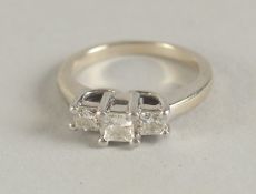 A 14CT GOLD, PLATINUM AND DIAMOND THREE STONE RING with emerald cut diamonds.
