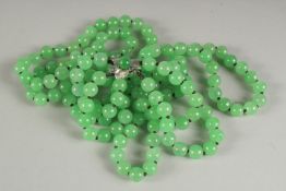 A VERY GOOD DOUBLE ROW JADE NECKLACE one hundred and twenty beads with gold flower clasp.