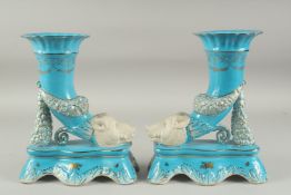 A PAIR OF SEVRES DESIGN BLUE PORCELAIN BOARS HEAD CORNUCOPIA VASES. 11ins high.