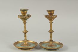A PAIR OF BRASS AND ENAMEL CIRCULAR CANDLESTICKS. 7ins high.