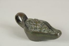 A ROMAN BRONZE OIL LAMP, the head of Bacchus. 13ins long.