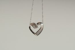 A 14CT WHITE GOLD AND DIAMOND HEART SHAPED PENDANT on a chain.