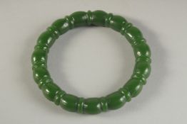 A CARVED DARK GREEN JADE BANGLE. 3ins diameter.