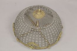 A BRASS UPLIGHER, BEADED CHANDELIER. 1ft 6ins high.