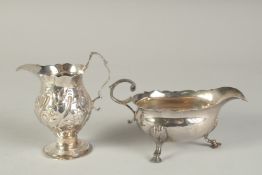 A GEORGE III SILVER SAUCE BOAT. London 1792 and a CREAM JUG (2).