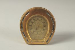 A GOOD SMALL HORSE SHOE SHAPED TRAVELLING CLOCK. 3ins x 2.5ins in a fitted leather case.