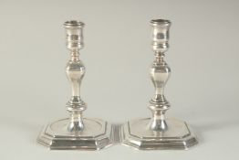 A MATCHED PAIR OF GEORGE I SILVER AND GEORGE II SILVER CAST CANDLESTICKS. London 1725 & 1735.
