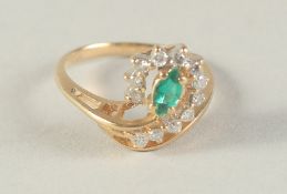 AN 18CT GOLD DIAMOND AND EMERALD RING.