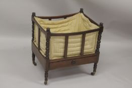 A GEORGIAN MAHOGANY CANTERBURY with turned supports, slatted sides and single drawer supported on