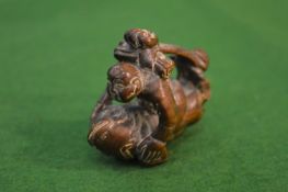A carved wood monkey netsuke.