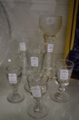 A large engraved glass goblet with air twist stem, a similar smaller drinking glass and four cut