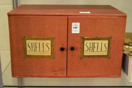 A good red paper cloth covered two door, three drawer collectors cabinet containing numerous