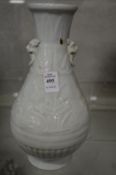 A Chinese celadon glazed vase with mask handles.