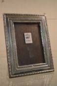 An embossed silver photograph frame, photo size 4.¾