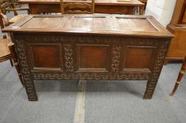 A 17th century oak coffer with triple panelled rising top above a triple panelled front with