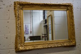 A decorative large gilt framed rectangular wall mirror.