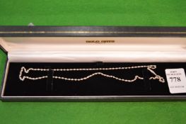 A platinum and seed pearl necklace.