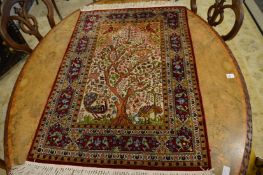 A small silk Persian tree of life rug.