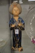 A Chinese pottery figure of a standing women.