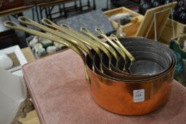 A good set of seven copper and brass graduated saucepans.