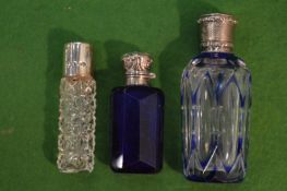 Three cut glass scent bottles with silver mounts.