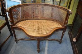 A good carved walnut and cane seated bergere style small settee with curving back.